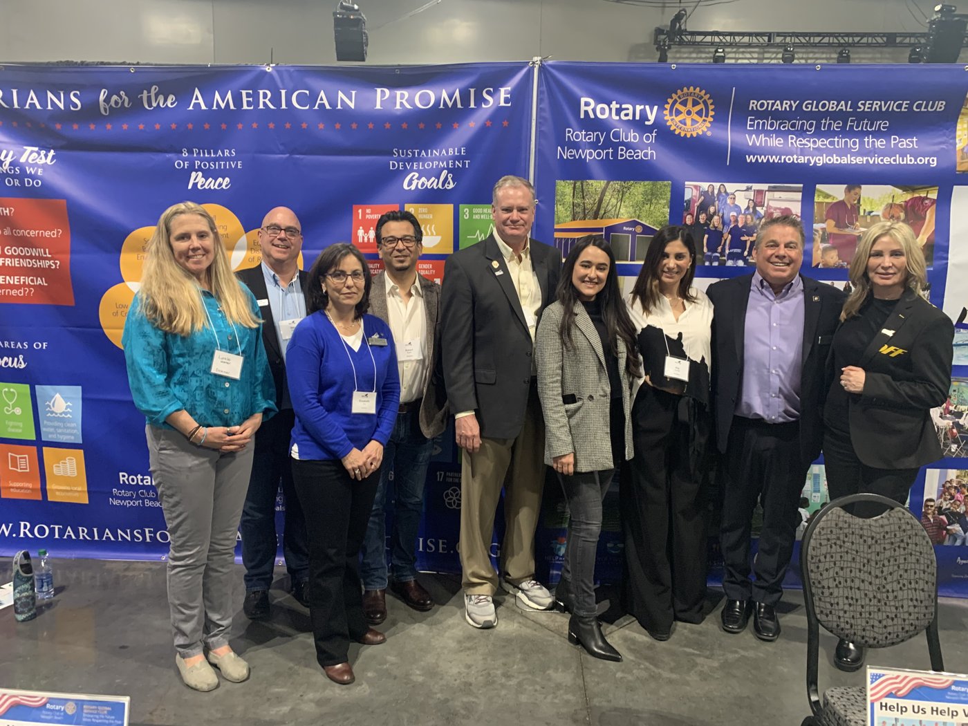 Members of the Rotary Club of Newport Beach and guests in front of the club's two booth banners at the Rotary World Peace Conference